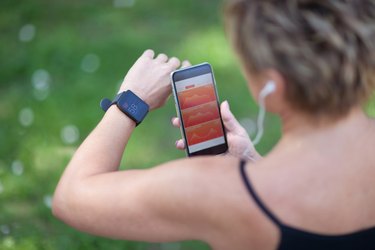 Jogger checking calorie progress on smart phone and smart watch