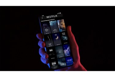 Restflix app on a smartphone screen on a black background, one of the best sleep apps