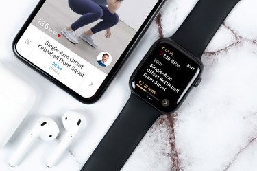 An iPhone and Apple Watch on a white marble background with the Future fitness app displayed on the screens