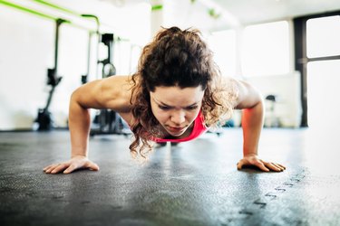 Person performing a push-up in a gym.