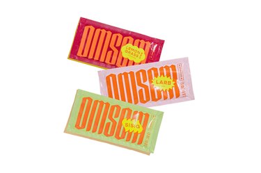 three omsom sauce and spice packets on a white background