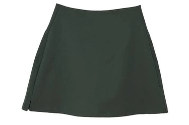 Dark green Girlfriend Collective brand tennis skirt on a white background