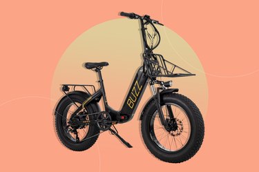 Close-up of a black Buzz Centris foldable e-bike on a salmon pink background.