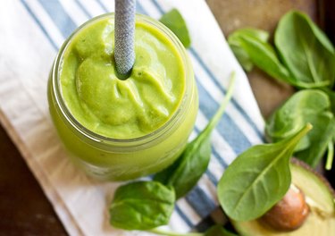 avocado green smoothie with spinach and avocado on wooden table