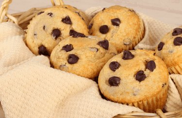 A basket of golden brown chocolate chip muffins.