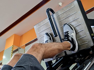 close up of a person's legs with their feet lower on the leg press to target their quads