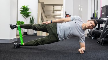 Man doing side plank with mini resistance band