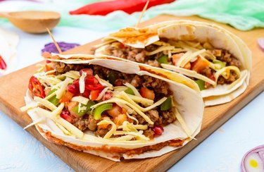 Stuffed Turkey Breakfast Skillet Burritos with tortillas on a wooden cutting board