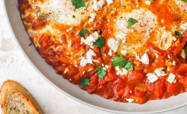 Easy Shakshuka Breakfast Skillet on a white plate with crusty bread