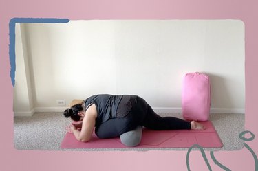 Yoga for All Bodies creator and instructor Natalia Tabilo on a yoga mat during yoga challenge doing pigeon pose with a bolster