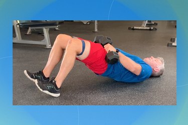 trainer Pete McCall doing a dumbbell glute bridge with a mini band