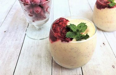 peach melba smoothie in a glass with green garnish