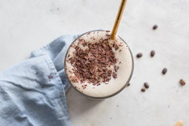 Coffee Lovers Protein Shake with cacao nibs and a gold straw