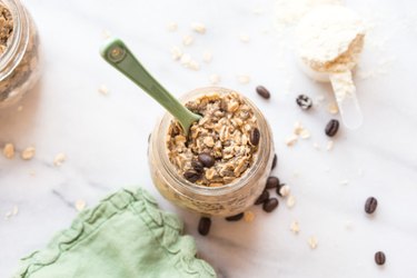 Cold Brew Coffee Overnight Proats in a mason jar with a green spoon and green cloth napkin