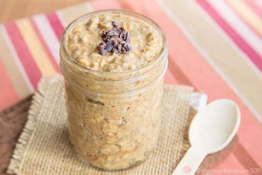 Pumpkin Spice Latte Overnight Oats in a mason jar with a white spoon