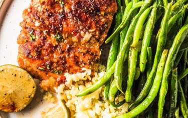 Stir fry  Asian Honey Glazed Salmon And Green Beans with white rice and lime wedges