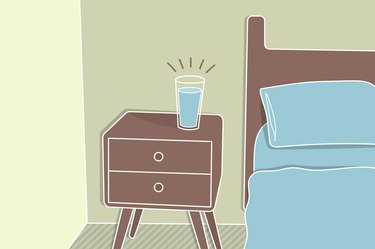 cartoon illustration of a glass of water on a nightstand beside a bed
