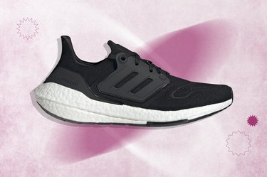 Black and white Adidas Ultraboost 22 running shoe on purple background.