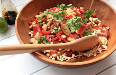 Asian Chicken Stir-Fry Salad in a wooden bowl with a wooden spoon