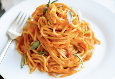 A close up of pumpkin pasta sauce on some spaghetti