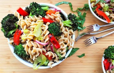 Warm Italian Pasta Salad With Charred Broccoli and Bell Pepper in white bowl on wooden table