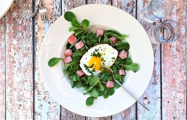 Organic Ham and Egg Breakfast Bistro Salad in white bowl on wooden table