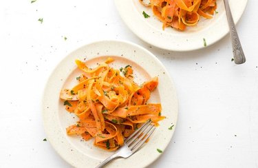 Tangled Warm Carrot Salad With Tahini Vinaigrette on white plates