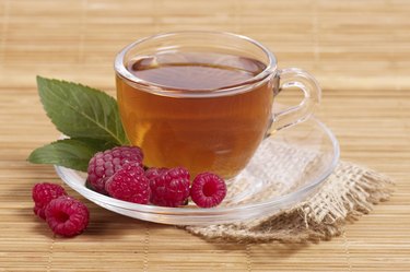 Fruit tea in cup with raspberry