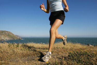 Woman running along coastline,  California,  USA