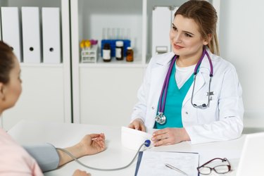 A nurse is taking a patient's blood pressure.