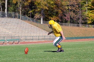 Football kicker practicing on field