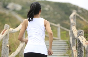 woman runner running at mountain stairs