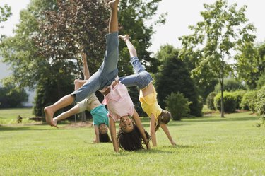 Girls doing cartwheel in field
