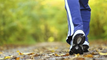 Woman walking cross country trail in autumn forest