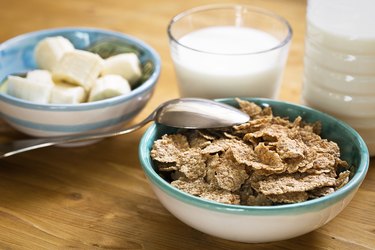 Delicious and healthy wheat flakes in bowl with milk