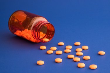 Orange pills spilling out of orange bottle
