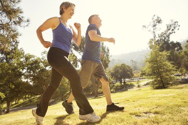 Mature couple power walking in park