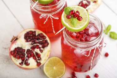 Two glasses with red pomgranate juice, lime and mint.