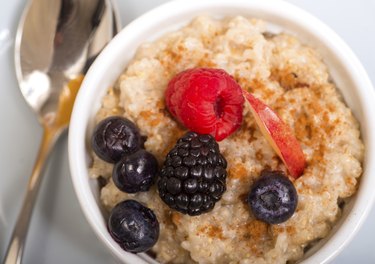 Bowl of steel-cut oats served with fresh fruit and honey
