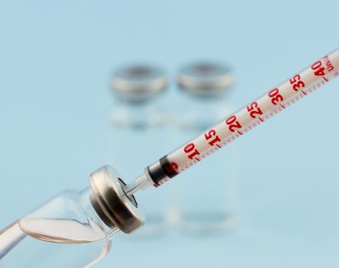 Medical ampoule with insulin syringe and two ampoules behind