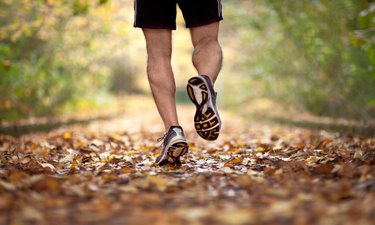 runner's lower legs on leafy trail