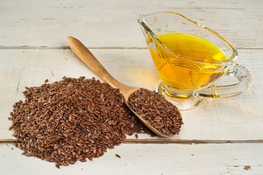 brown flax seed and linseed oil, on wooden table