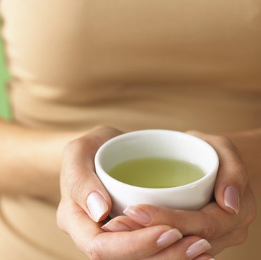 Woman holding cup of green tea