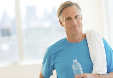 Confident Man With Towel And Water Bottle At Club