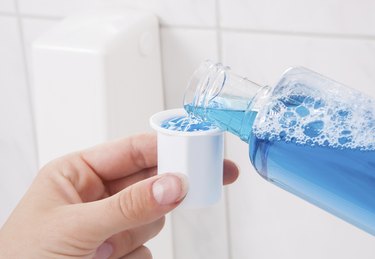 Hand Holding Bottle Of Mouthwash