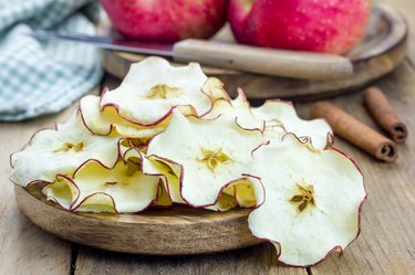 Healthy snack. Homemade apple chips on rustic wooden background