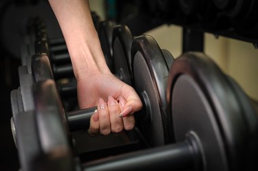 Female hand holding dumbbell