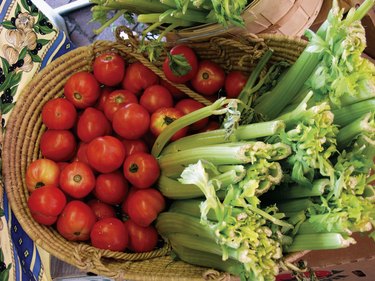 A basket of tomatoes and celery stalks