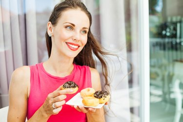 happy smiling woman eating a donut