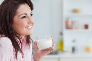 Side view of woman with glass of milk